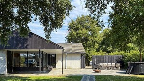 A modern house with a covered patio, a brick garage, and a lawn. - 6 Person Holiday Home in Albaek (Aalbaek)