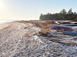 A beach with a boat and some pipes on the sand. - 6 Person Holiday Home in Thyholm (Thyholm)