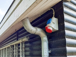 Exterior de un edificio con sistema de desagüe metálico y una llave de color rojo y azul.