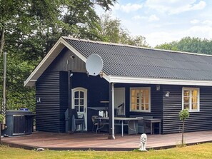 A log cabin with a porch, outdoor seating, and a satellite dish. - 6 Person Holiday Home in Thyholm (Thyholm)