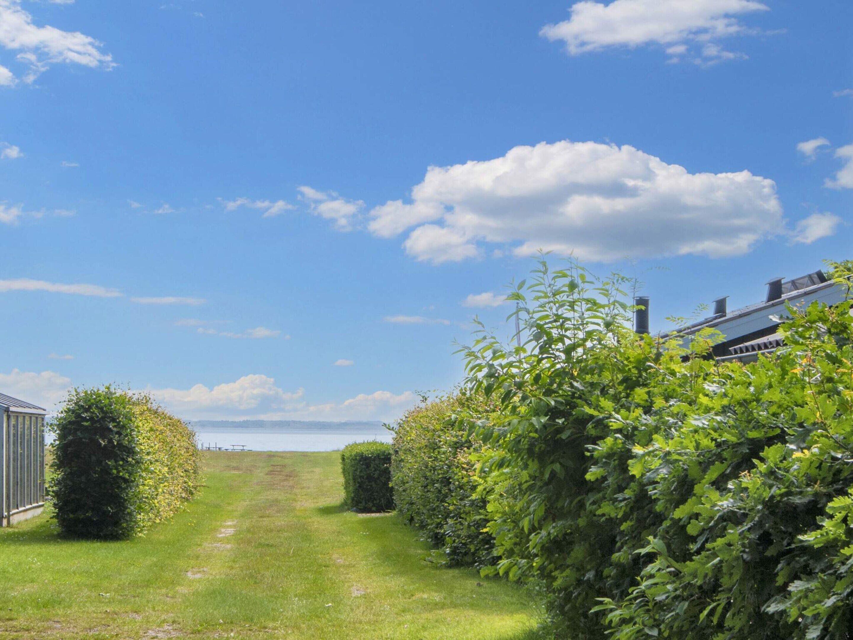 A pathway leading to a building with a view of the sea.