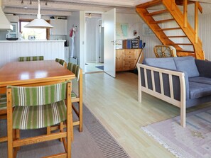 A cozy interior with a wooden dining table, striped chairs, a blue sofa, and a staircase. - 6 Person Holiday Home in Hadsund (Hadsund)