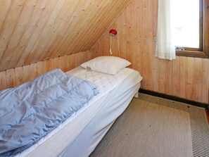 A single bed in a room with wooden walls and a sloped ceiling. - 6 Person Holiday Home in Hadsund (Hadsund)