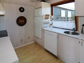Cocina funcional con lavavajillas, pileta y ventana con vistas al exterior.