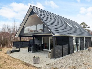 A modern house with a covered patio, large windows, and a number 19 on the door. - 6 Person Holiday Home in Laeso-by Traum (Læsø)