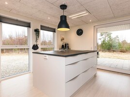 Una cocina moderna con una isla central, ventanas amplias y vistas al exterior.