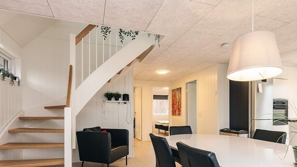 Et moderne interiør med trappe, spiseplads og køkken.