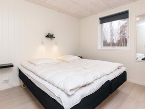A bedroom with a bed, bedside lamps, a window, and a wall-mounted plant. - 6 Person Holiday Home in Laeso-by Traum (Læsø)