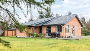 A single-story house with a brick exterior, a tiled roof, and a covered patio area with outdoor furniture. - 5 Person Holiday Home in Bording (Bording)