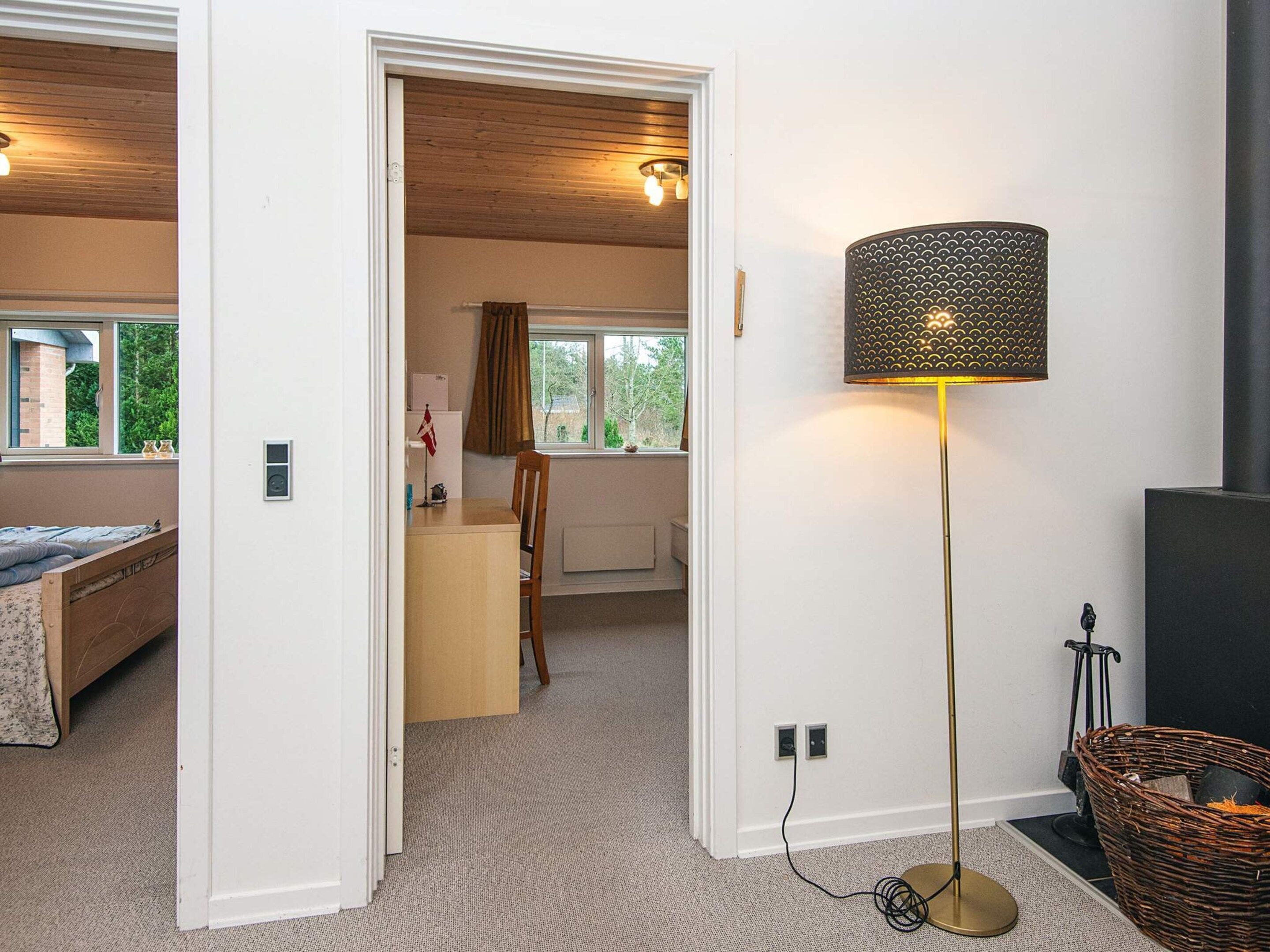 A room with a bed, a desk, a lamp, and a window.
