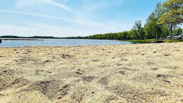 A sandy beach with a lake in the background and trees on the right. - 6 Person Holiday Home in Tingsryd-by Traum (Tingsryd)