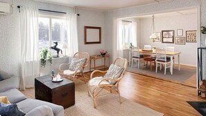 A cozy living room with a sofa, two wicker chairs, a wooden coffee table, and a dining area with a table and chairs. - 6 Person Holiday Home in Tingsryd-by Traum (Tingsryd)