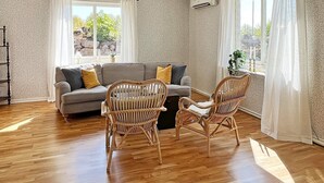 A living room with a sofa, two wicker chairs, a coffee table, and a window with curtains. - 6 Person Holiday Home in Tingsryd-by Traum (Tingsryd)