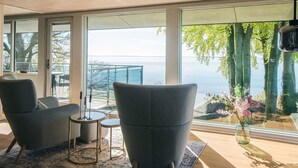 Un intérieur moderne avec de grandes fenêtres, un balcon et une vue sur la mer.