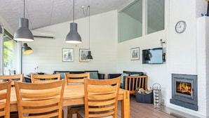 Uma sala de estar moderna com lareira, móveis de madeira e janelas amplas.