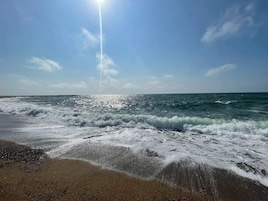 Una playa con olas y cielo despejado.