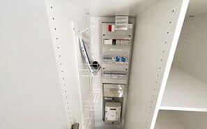 A utility room with electrical panels and a ladder.