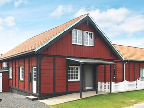 A red building with a gabled roof and a white picket fence. - 10 Person Holiday Home in Marstal (Marstal)