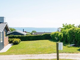 Zona residencial con césped, un camino pavimentado y vista al mar.