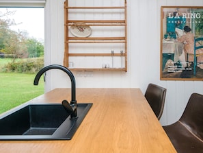 A kitchen with a black sink, wooden shelves, and a framed picture on the wall. - 6 Person Holiday Home in Ronde (Ronde)