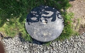 A circular manhole cover with the inscription 'MALERIBOTAN' on a gravel surface. - 4 Star Holiday Home in Vaeggerlose (Vaeggerlose)
