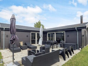 A patio area with outdoor furniture, a grill, and a covered umbrella. - 4 Star Holiday Home in Vaeggerlose (Vaeggerlose)