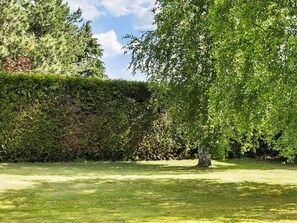 A well-maintained garden with a variety of trees and a neatly trimmed hedge. - 14 Person Holiday Home in Ronne (Akirkeby)