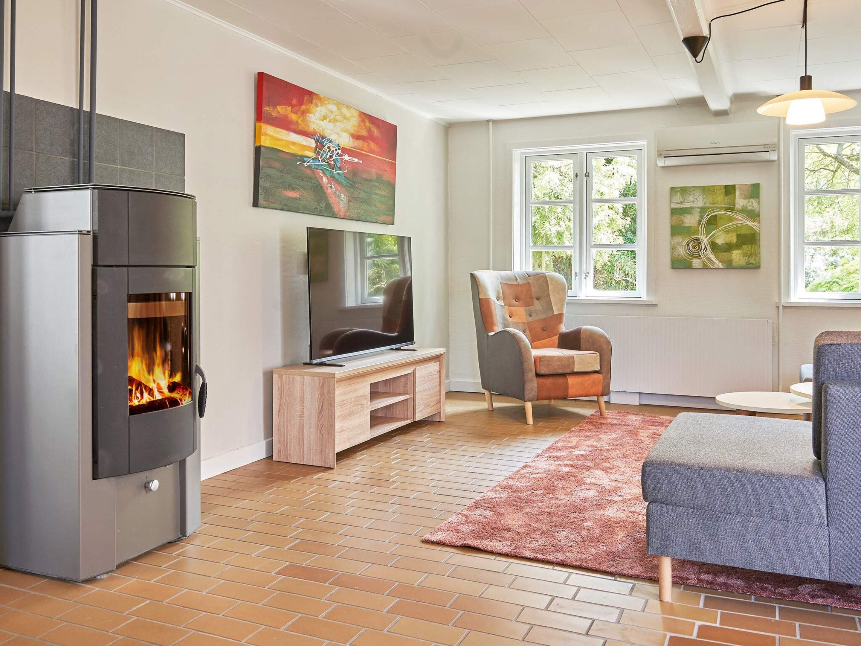 Una sala de estar con chimenea, televisor y un espacio de descanso cómodo.