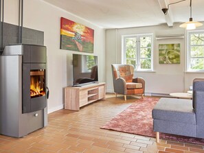 Un salon doté d’une cheminée, d’un téléviseur et d’un coin salon confortable.