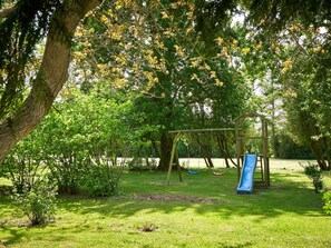 Um parque com baloiço e escorrega.