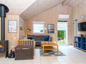 A cozy living room with a sofa, a coffee table, and a fireplace. - 6 Person Holiday Home in Oksbol (Oksbol)