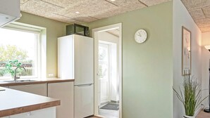 Una cocina moderna con armarios blancos, un microondas sobre la encimera y vistas al exterior a través de una ventana.