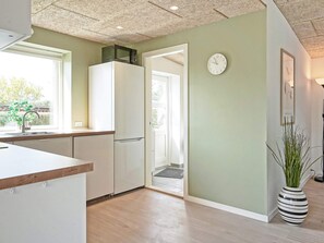 A modern kitchen with white cabinets, a microwave, and a sink.