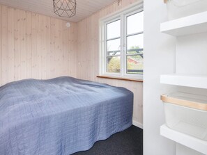 A room with a bed, a window, and a white shelf with a basket. - 6 Person Holiday Home in Bjert (Bjert)