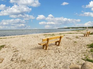 A beach with two wooden benches facing the sea. - 6 Person Holiday Home in Bjert (Bjert)