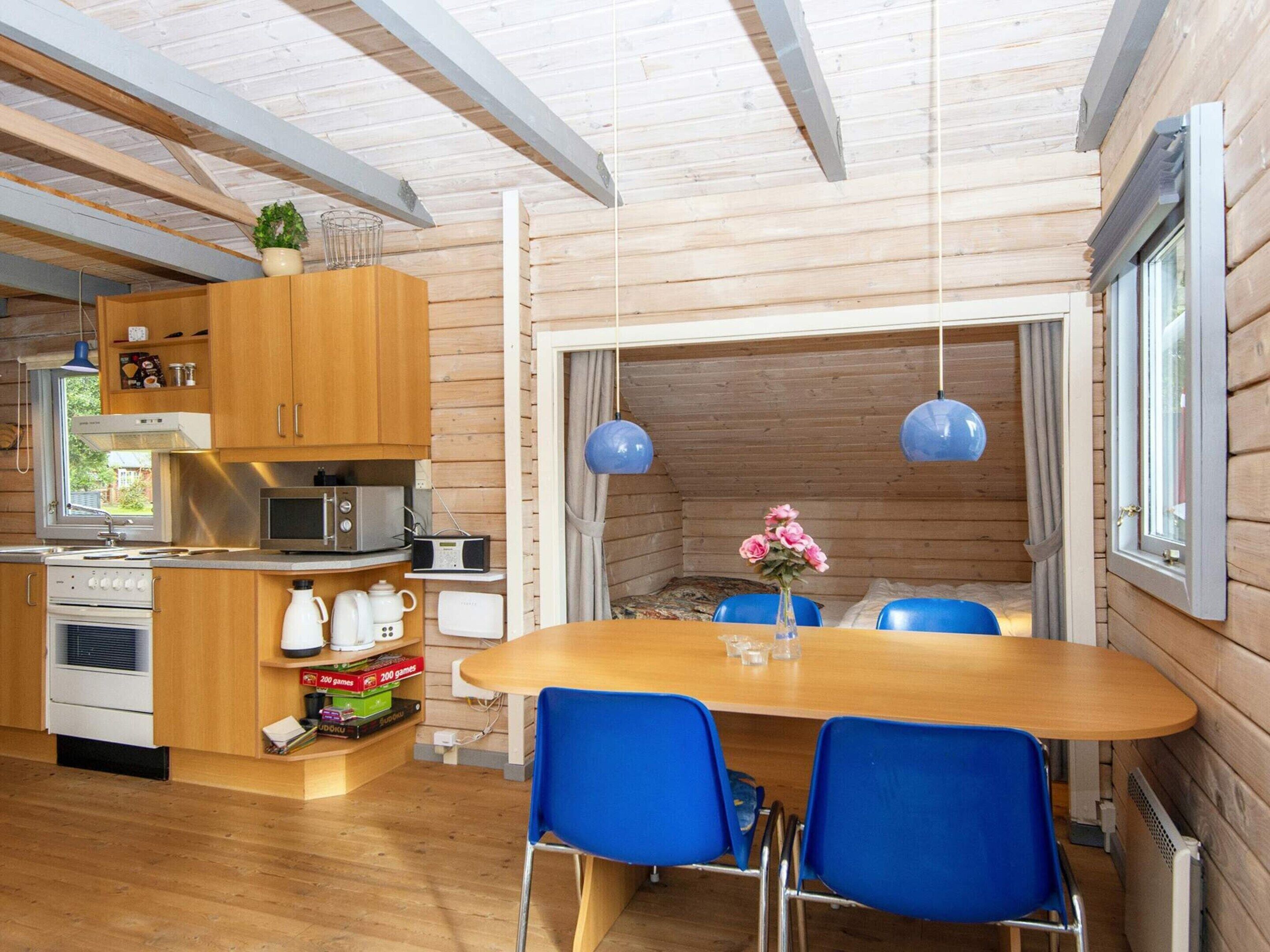 Una cocina compacta con armarios de madera, un microondas y una estufa.