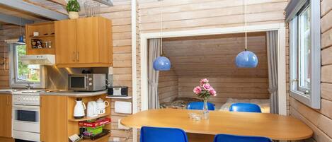 Una cocina compacta con armarios de madera, un microondas y una estufa.