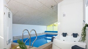 A modern indoor pool area with a hot tub and a shower. - 10 Person Holiday Home in Juelsminde-by Traum (Horsens)