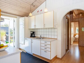 Een moderne keuken met witte kasten, een koffiezetapparaat en een spoelbak.