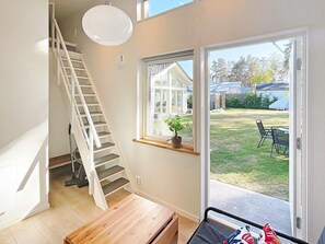 Un interior moderno con una escalera, un ventanal con vistas al exterior y un banco.