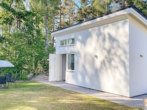 A modern two-story house with a white exterior, a front door, and a small porch area.