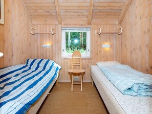 Una habitación con dos camas, una ventana y una silla.