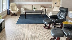 A living room with a beige sofa, a black leather chair, a coffee table, and a blue rug. - 10 Person Holiday Home in Tynset-by Traum (Tynset)