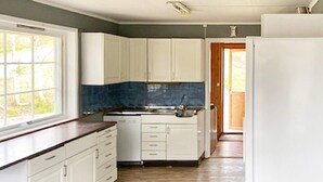 A kitchen with white cabinets, a wooden countertop, and a view of the outdoors through a window. - 10 Person Holiday Home in Tynset-by Traum (Tynset)