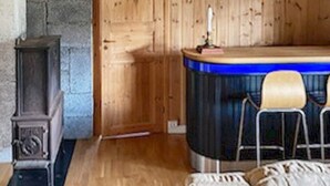 A room with a wooden door, a bar area with stools, and a small table with a candle. - 10 Person Holiday Home in Tynset-by Traum (Tynset)