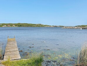 Enjoy serene waterfront views from the weathered pier, perfect for relaxation or outdoor activities.