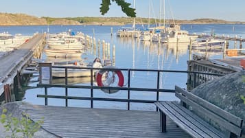 A wooden dock leading to a marina with boats docked.