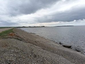 A gravel path beside a body of water with a cloudy sky. - 6 Person Holiday Home in Thisted (Thisted)