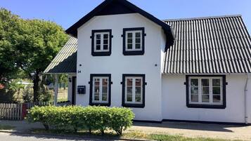 A two-story white building with black trim and a sloped roof.