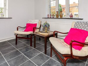 A room with two wooden chairs, a small table with a globe, and a window with decorative vases. - 6 Person Holiday Home in Thisted (Thisted)